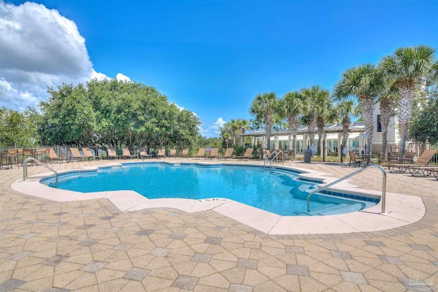 pool with a patio and fence