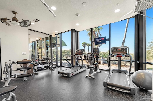 exercise room featuring recessed lighting, visible vents, a textured ceiling, and floor to ceiling windows