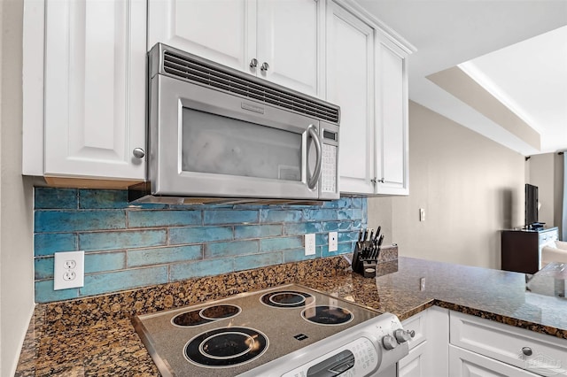 kitchen featuring stainless steel microwave, white cabinetry, tasteful backsplash, and electric stove