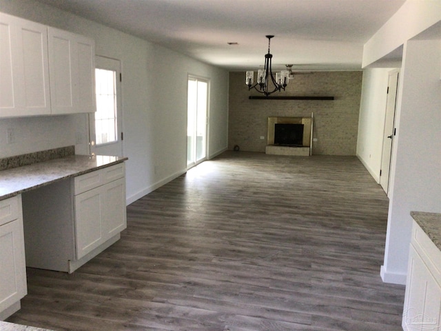 kitchen with a wealth of natural light, a large fireplace, and dark wood-type flooring