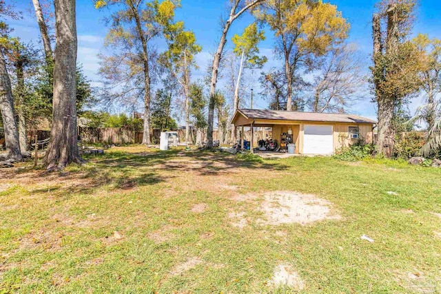 view of yard with a garage, a carport, and an outdoor structure