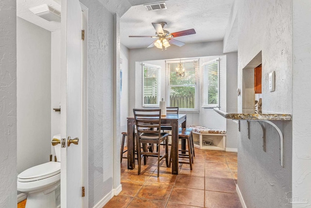 tiled dining room with a textured ceiling and ceiling fan