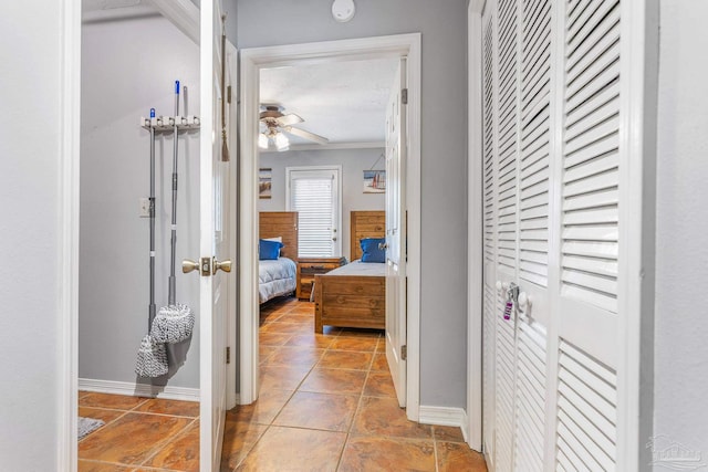 hallway with light tile patterned flooring and ornamental molding