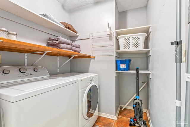 clothes washing area with washer and clothes dryer and light tile patterned floors