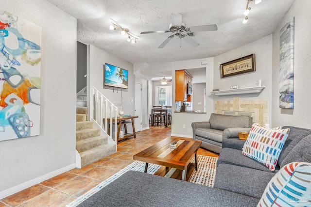 living room featuring ceiling fan, rail lighting, and a textured ceiling