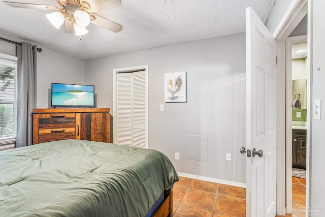 tiled bedroom with ceiling fan and a textured ceiling