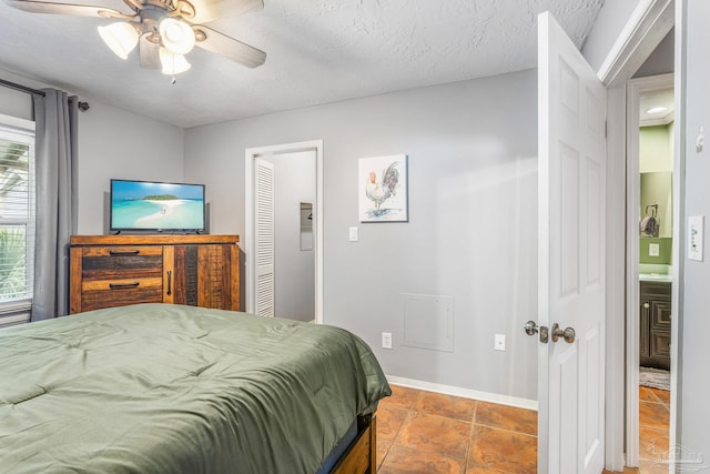 bedroom featuring a closet, tile patterned floors, connected bathroom, a textured ceiling, and ceiling fan