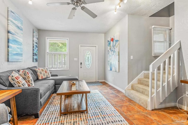 tiled living room with ceiling fan and track lighting