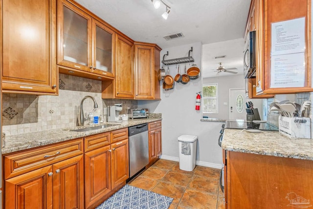 kitchen featuring stainless steel appliances, rail lighting, tasteful backsplash, sink, and ceiling fan