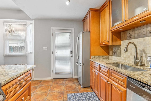 kitchen with sink, backsplash, a healthy amount of sunlight, and stainless steel appliances