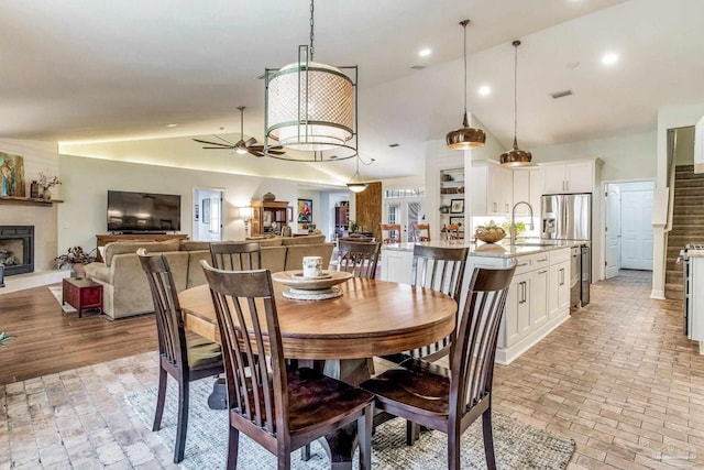 dining space featuring ceiling fan, high vaulted ceiling, and sink