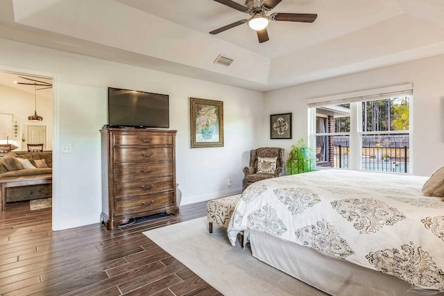 bedroom featuring dark wood-type flooring, ceiling fan, a tray ceiling, and vaulted ceiling