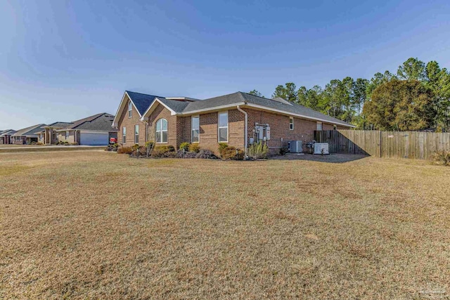 view of side of home with a garage, a lawn, and central air condition unit