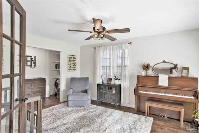 living area with ceiling fan and dark hardwood / wood-style flooring