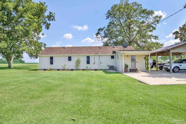 rear view of house with a carport, a yard, and central air condition unit