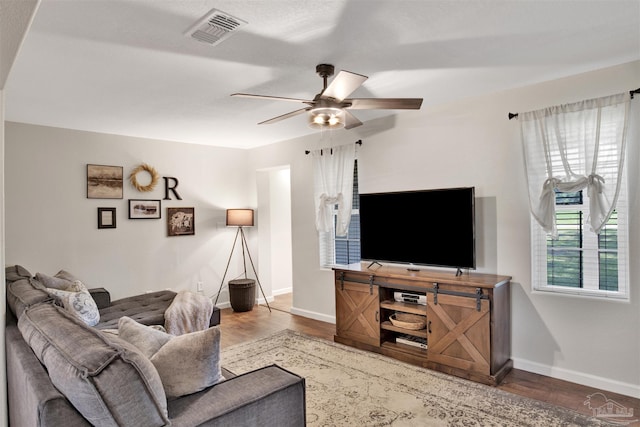 living room featuring hardwood / wood-style flooring, plenty of natural light, and ceiling fan