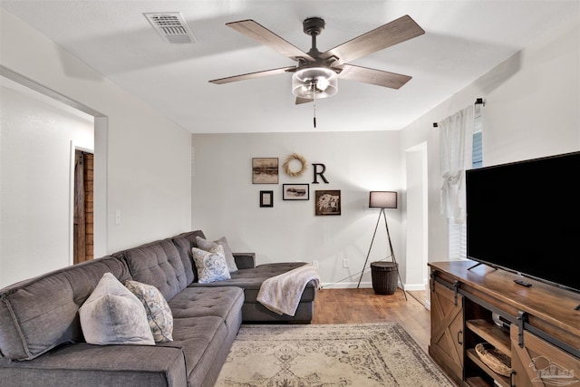 living room with light hardwood / wood-style floors and ceiling fan