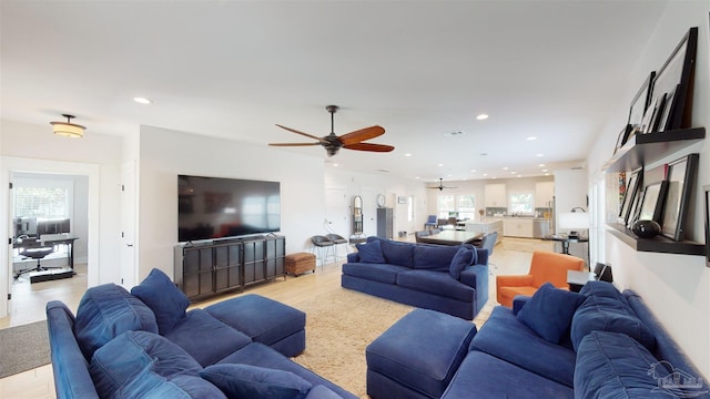 living room featuring light hardwood / wood-style floors, ceiling fan, and a wealth of natural light