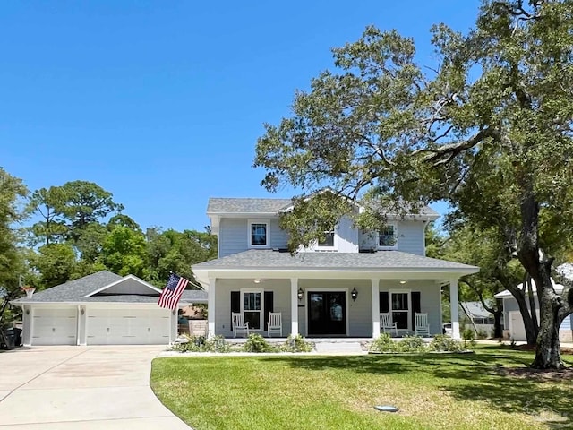 view of front of property featuring a garage, covered porch, and a front lawn