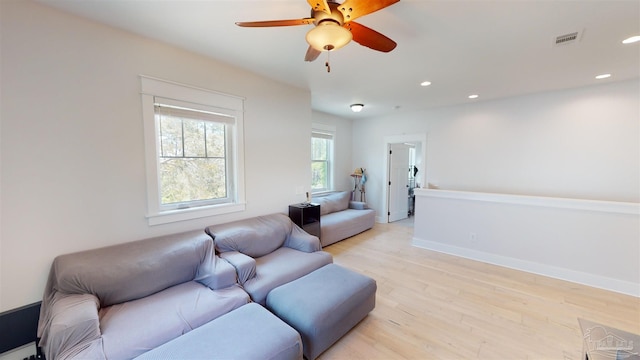 living room featuring light hardwood / wood-style floors and ceiling fan