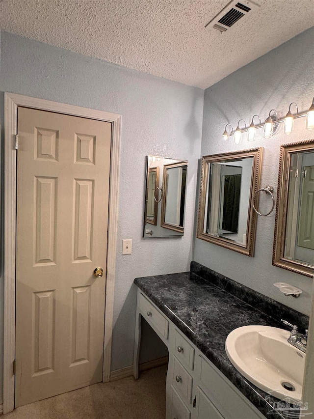 bathroom featuring a textured ceiling and vanity