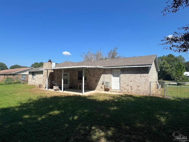 back of property with a patio and a yard