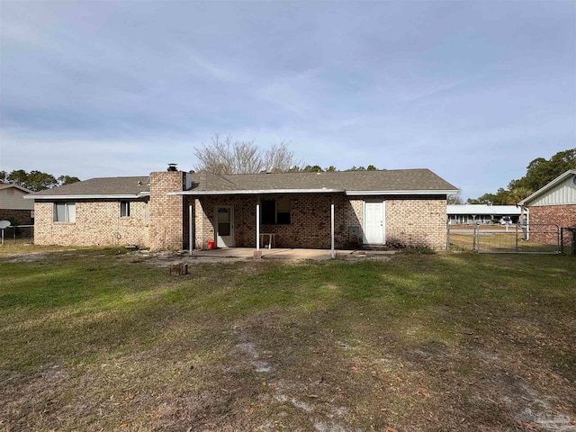 back of property with a patio and a yard