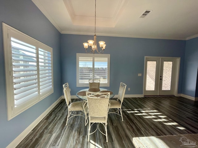 dining room with a raised ceiling, french doors, dark wood-type flooring, and a notable chandelier