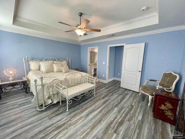 bedroom featuring hardwood / wood-style flooring, ceiling fan, a raised ceiling, and ornamental molding