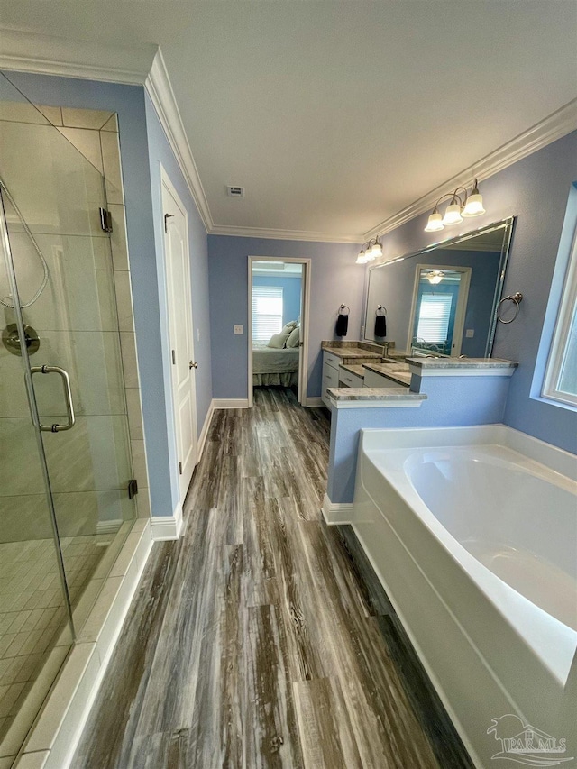 bathroom featuring wood-type flooring, vanity, independent shower and bath, and ornamental molding