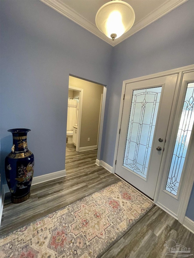 foyer with dark hardwood / wood-style floors and crown molding