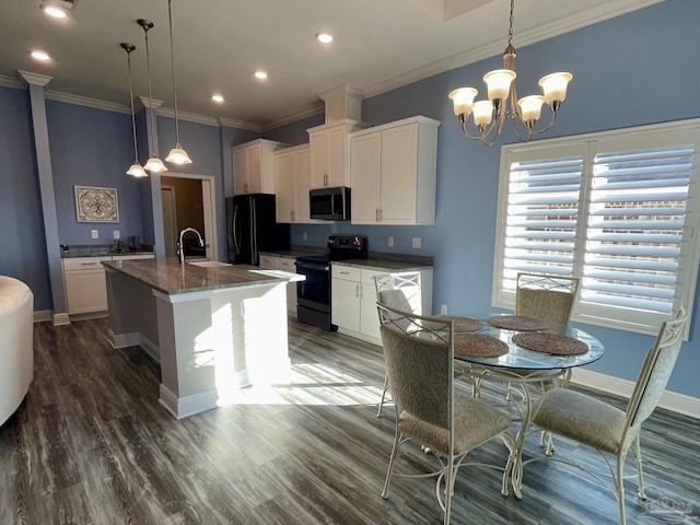 kitchen with white cabinets, pendant lighting, a center island with sink, and black appliances