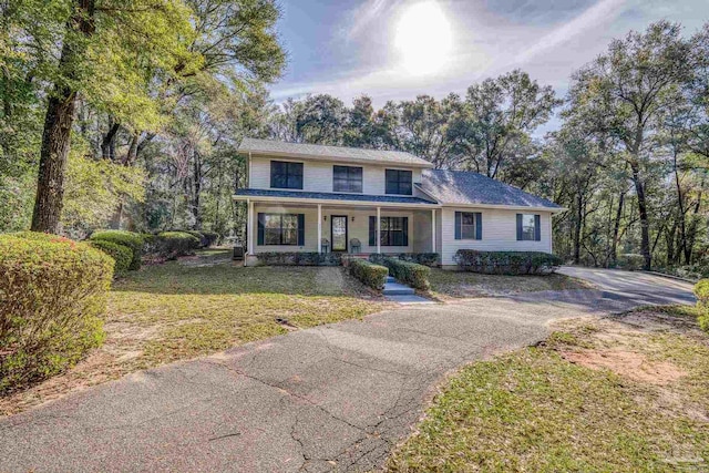 traditional-style home featuring a porch and a front lawn