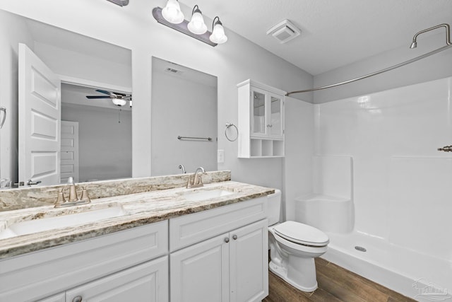 bathroom with ceiling fan, walk in shower, hardwood / wood-style floors, toilet, and vanity