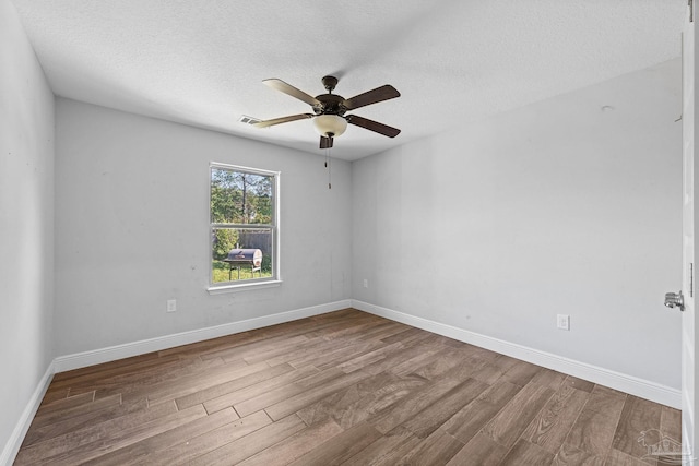 unfurnished room featuring hardwood / wood-style flooring, ceiling fan, and a textured ceiling