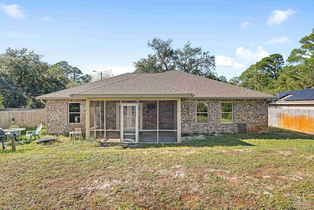 rear view of property featuring a sunroom and a yard