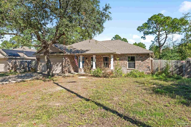 ranch-style home featuring a garage and a front lawn