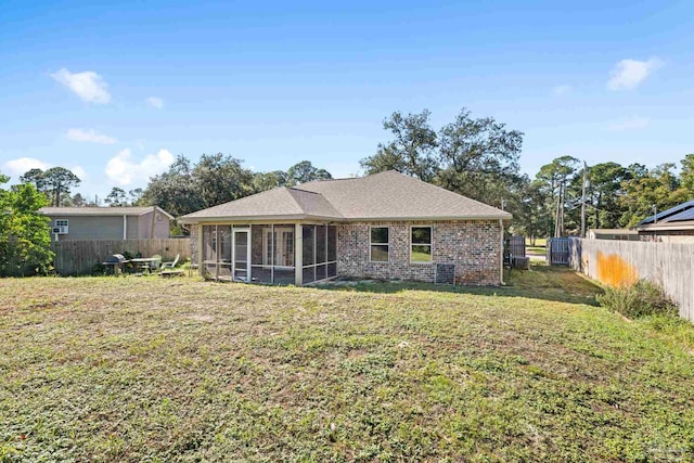 back of property featuring a lawn and a sunroom