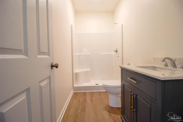 bathroom featuring toilet, vanity, walk in shower, and wood-type flooring