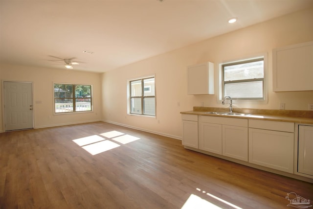 kitchen featuring white cabinetry, sink, light hardwood / wood-style flooring, and ceiling fan