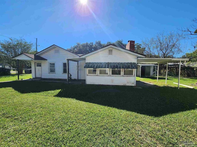 rear view of house with a yard and a carport