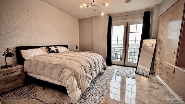 bedroom featuring access to outside, french doors, and brick wall