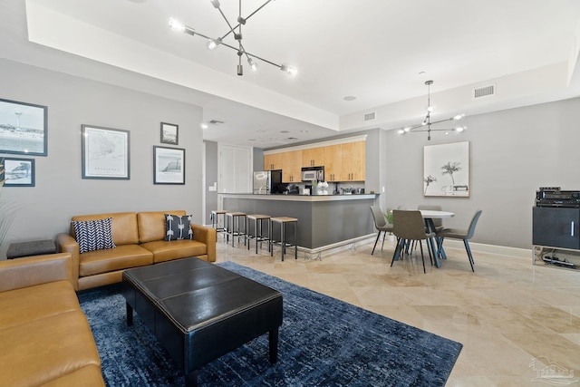 living room featuring a raised ceiling and a chandelier