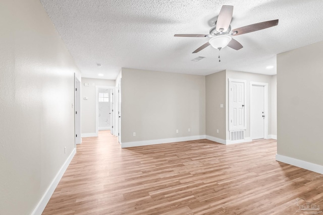 unfurnished room with a textured ceiling, light hardwood / wood-style flooring, and ceiling fan