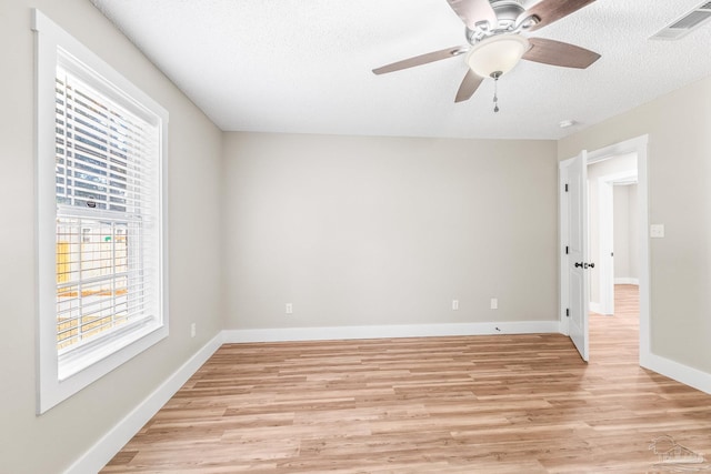 unfurnished room with ceiling fan, a textured ceiling, and light hardwood / wood-style flooring