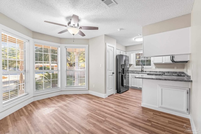 kitchen featuring light wood-type flooring, white cabinetry, ceiling fan, and fridge with ice dispenser