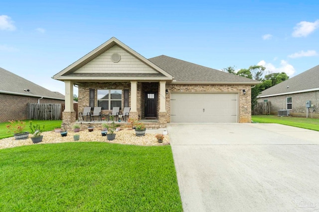 view of front of property with a garage, central AC, and a front lawn