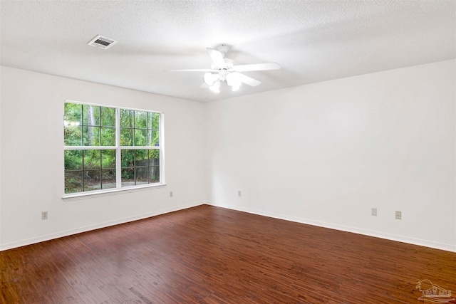 empty room featuring a textured ceiling, dark hardwood / wood-style flooring, and ceiling fan