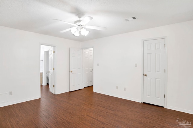 unfurnished room with a textured ceiling, dark wood-type flooring, and ceiling fan