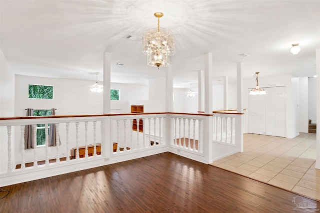 interior space featuring wood-type flooring, a notable chandelier, and a healthy amount of sunlight